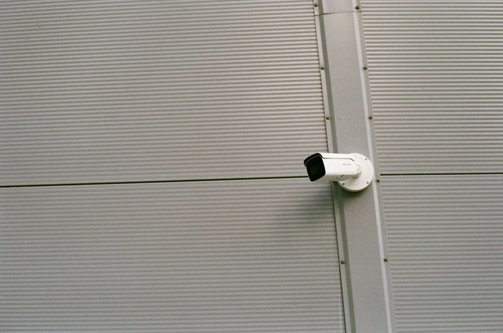 Security camera mounted on a corrugated metal wall.